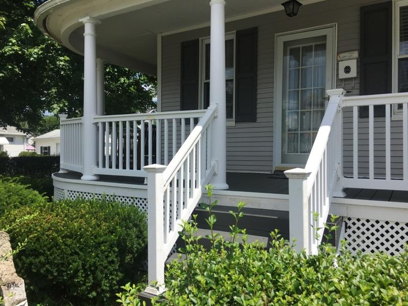Lovely covered, wrap around porch installation, with railings and steps